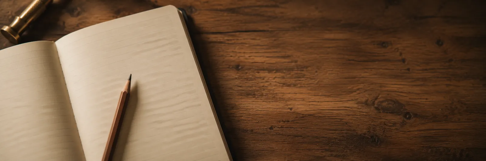Open notebook and pencil on a wooden bench.